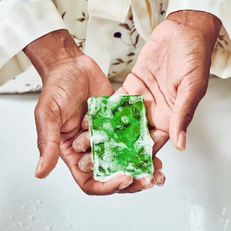 Hands holding a green handmade bar
