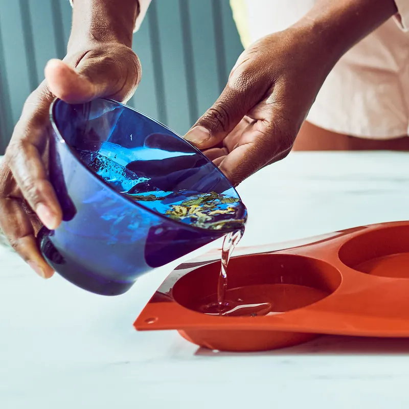Pouring blue melted soap into a mould
