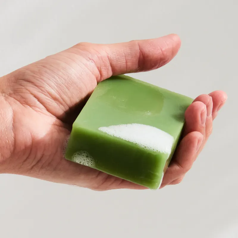 Hand holding a green handmade bar