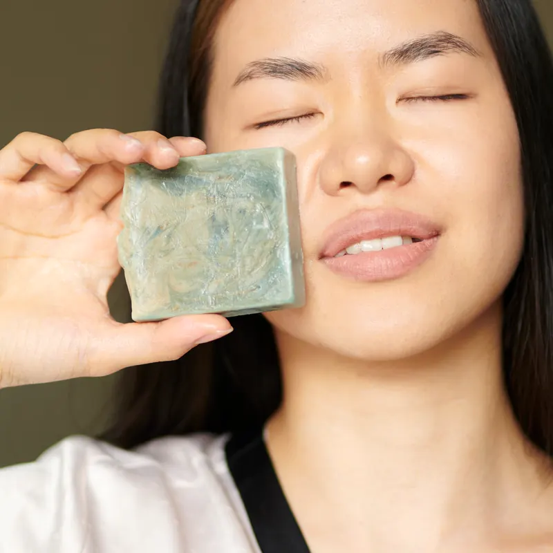 Woman holding a handmade bar to her cheek