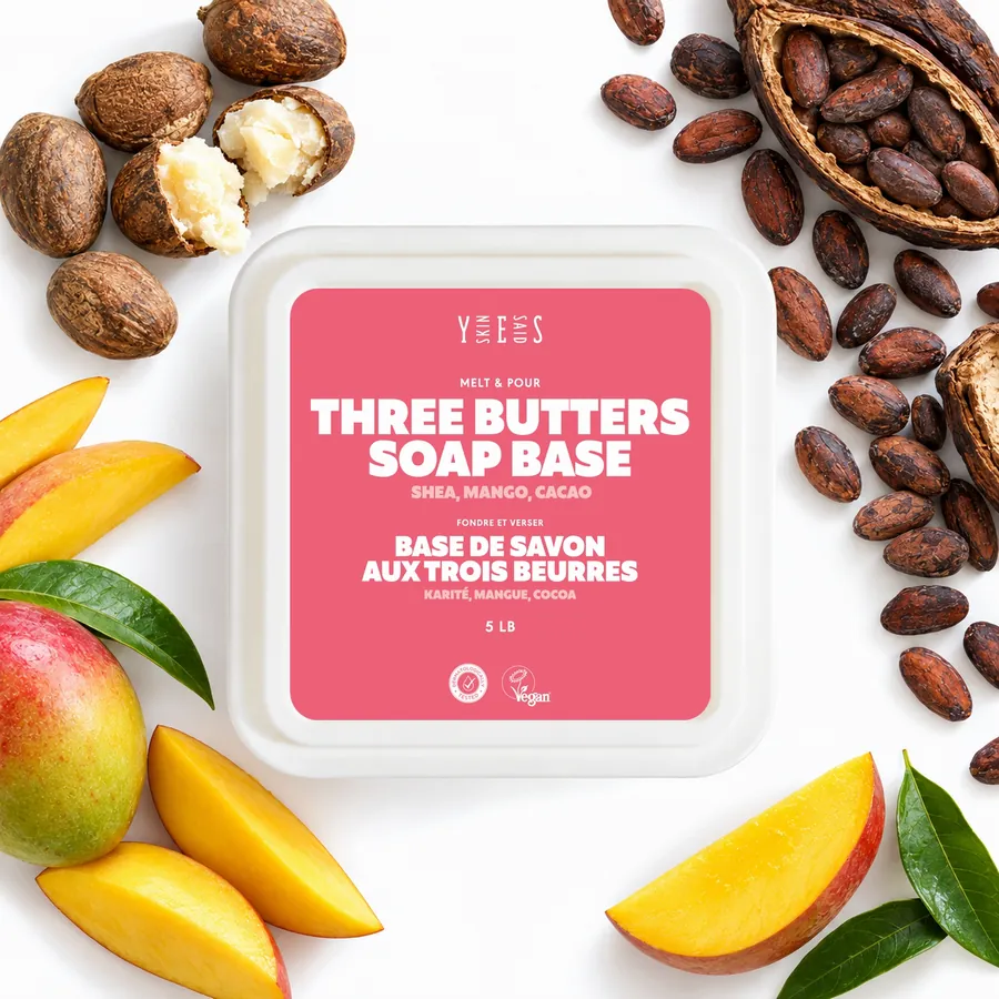 Three butters soap base tub from above, with shea nuts, cocoa beans and mango slices