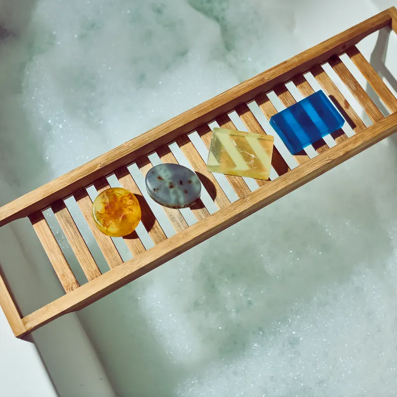 Clear and coloured handmade bars on a bath tray