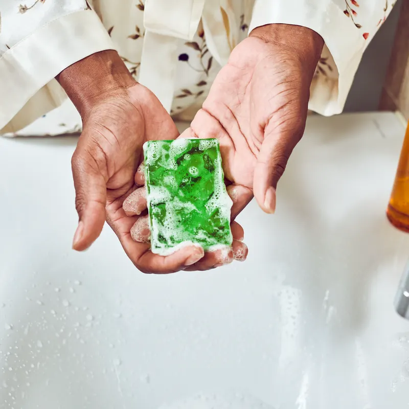 Hands holding a green handmade glycerin bar