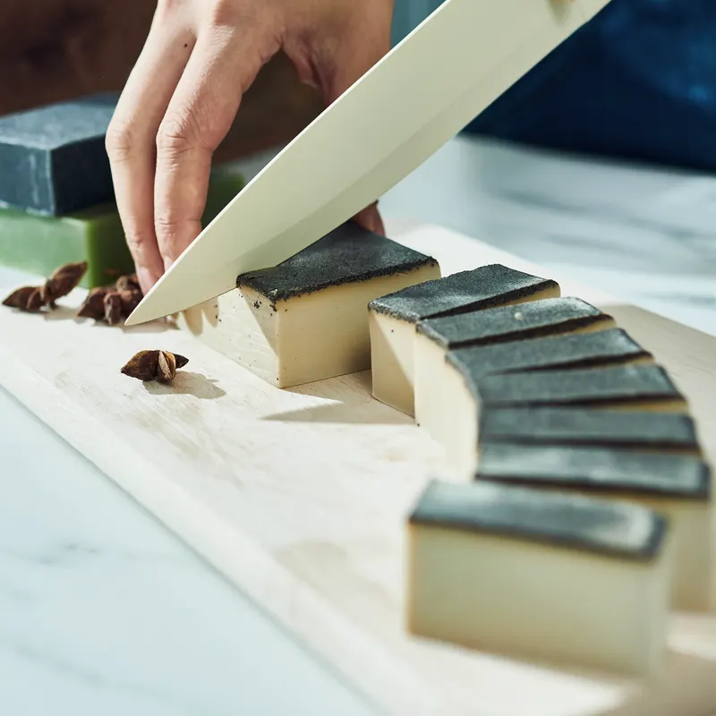 Cutting a loaf of layered handmade soap into bars