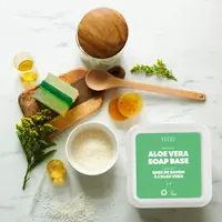 Aloe vera soap base tub on marble with finished bars and botanicals
