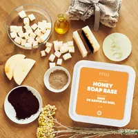 Honey soap base tub on a table with soap cubes and dried flowers