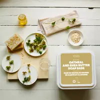 Oatmeal soap base tub on a table with botanicals and soap pieces