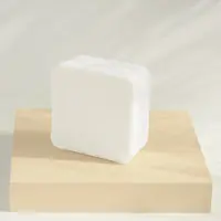 A block of shea butter soap base on a wooden stand