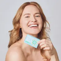 Smiling woman holding a boxed Skin Said Yes goat milk soap bar