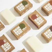 Unwrapped cream soap bars lying between their kraft cartons