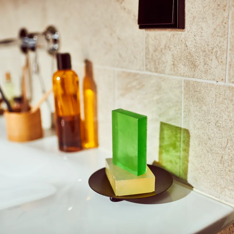 Green and clear layered glycerin bars by a sink